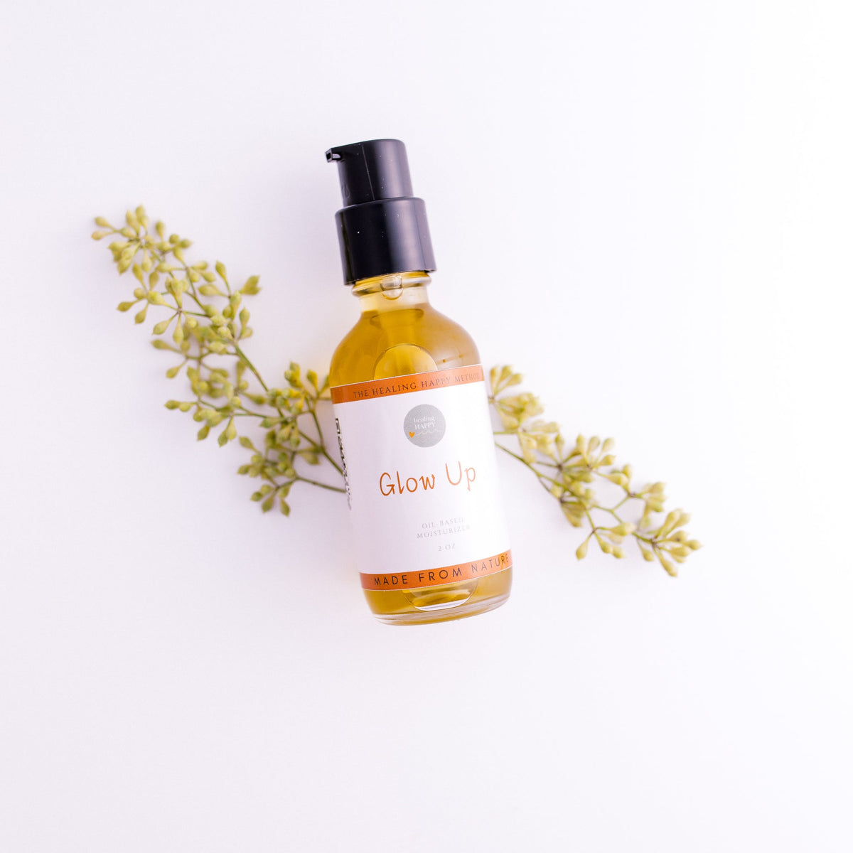 Face moisturizer bottle with pump, amber liquid in clear glass