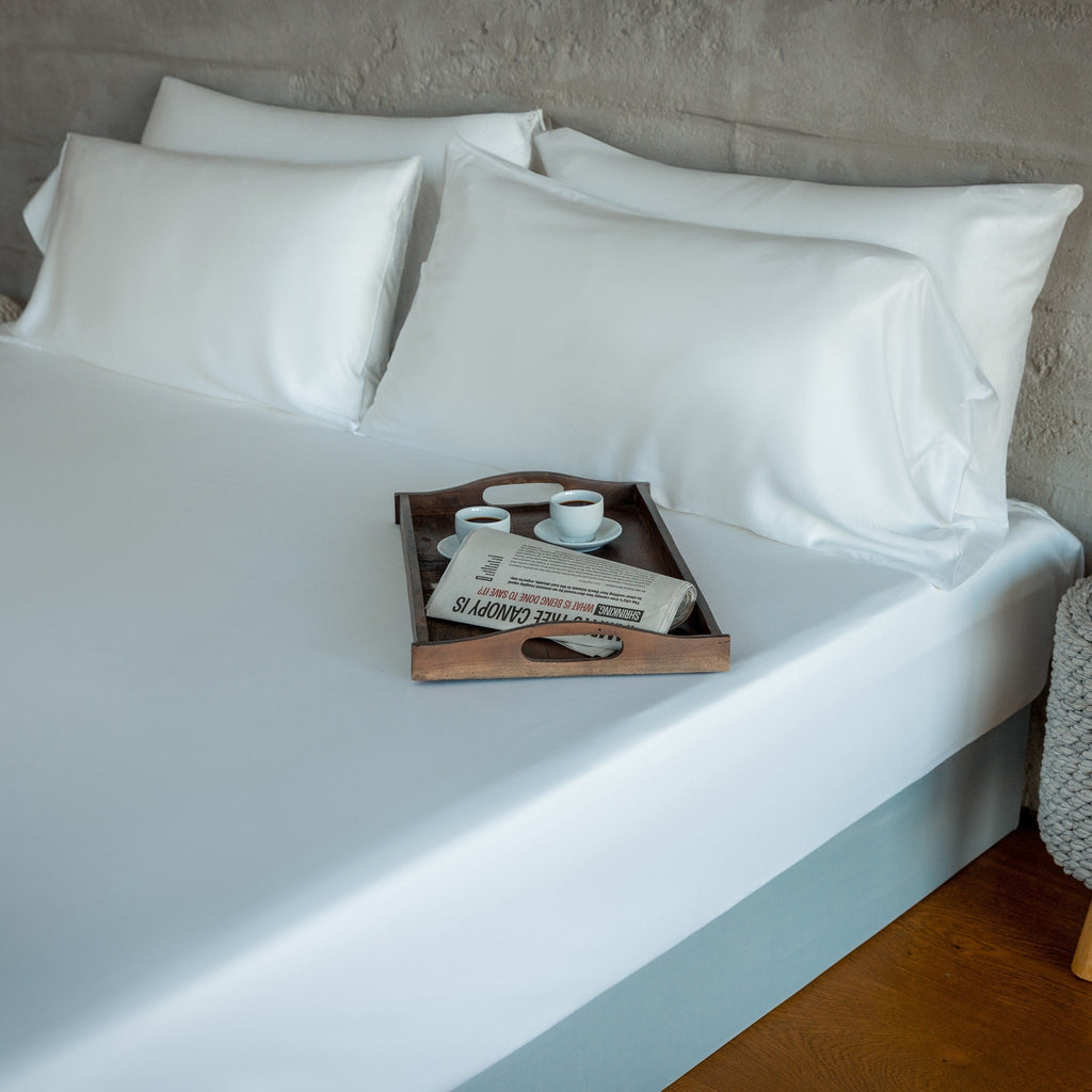 Light blue sheet set with three pillowcases on bed