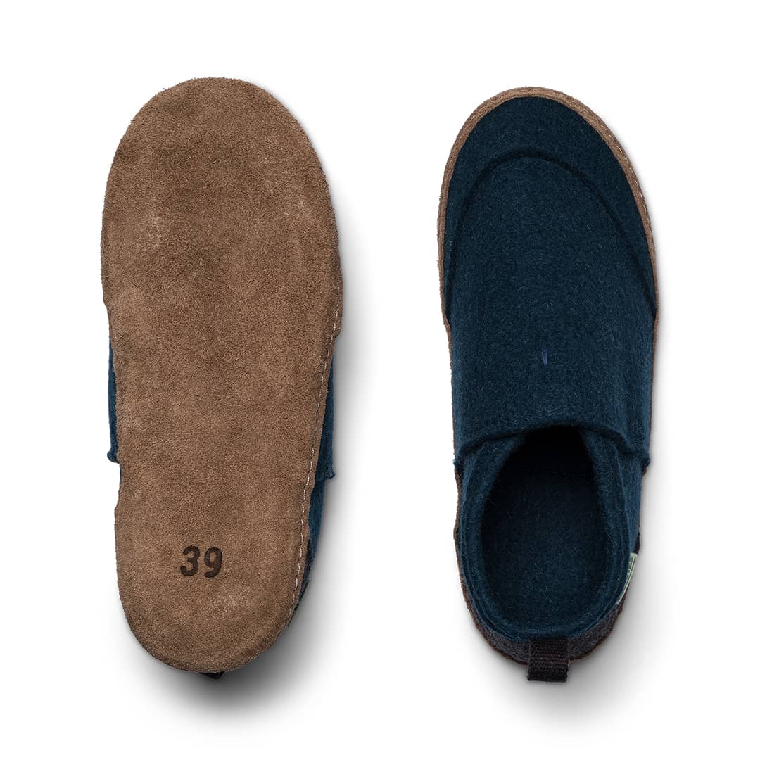 Slip-on slippers showing tan sole and dark blue interior lining