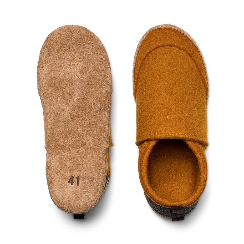 Slip-on slippers showing tan sole and orange interior lining