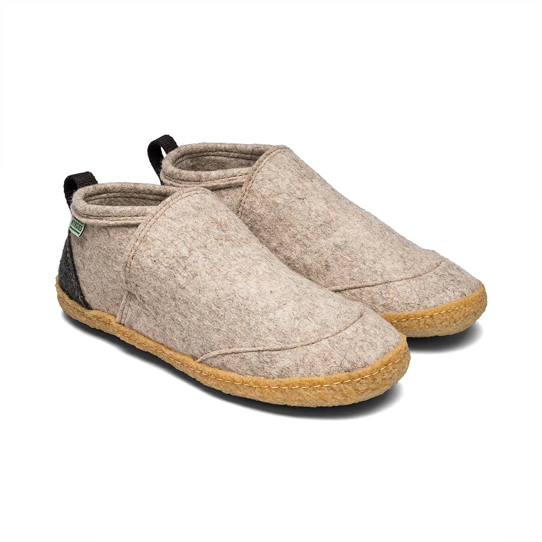 Beige felt slip-on shoes with tan rubber sole and black collar trim