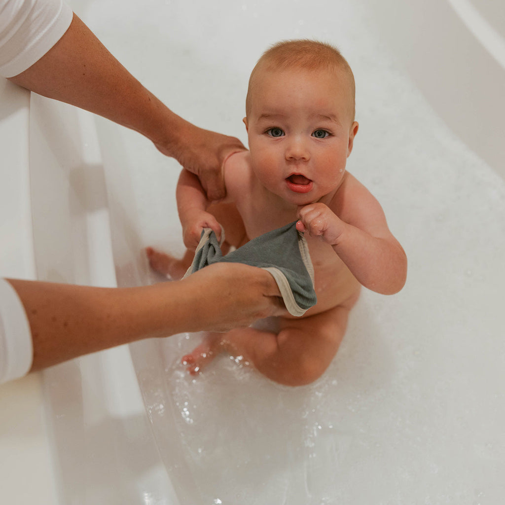Baby terry washcloth in gray being used during bath time