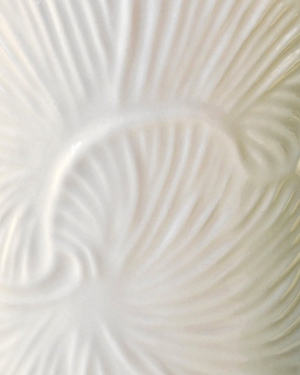 Close-up of embossed leaf pattern on white ceramic foaming soap dispenser body