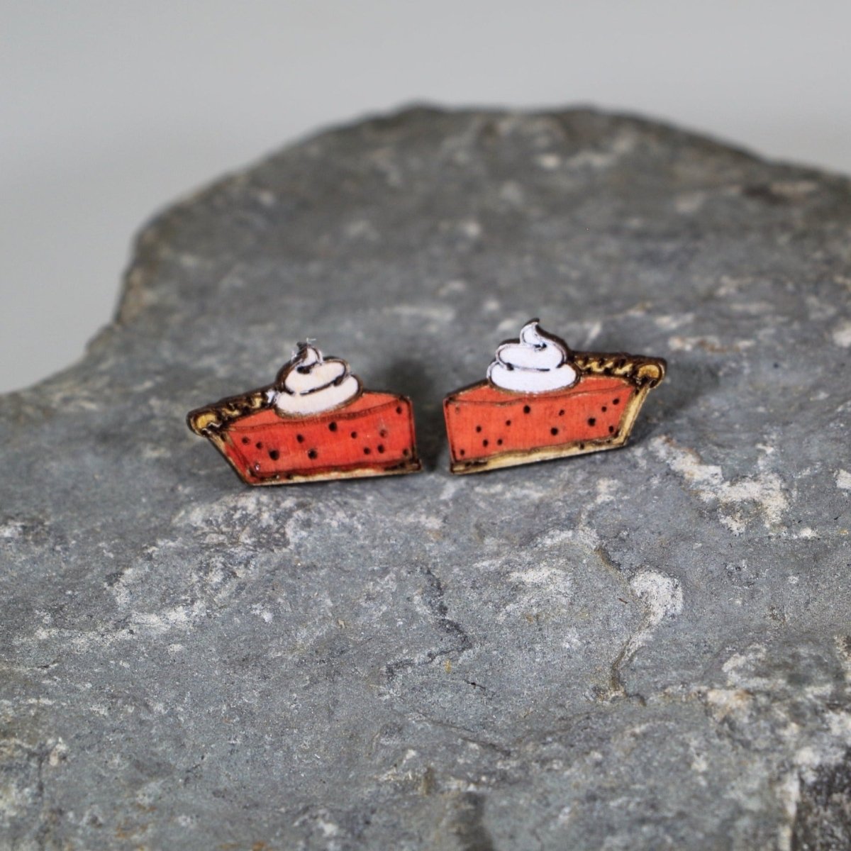 Wooden stud earrings featuring pumpkin pie slice charms with white cream topping