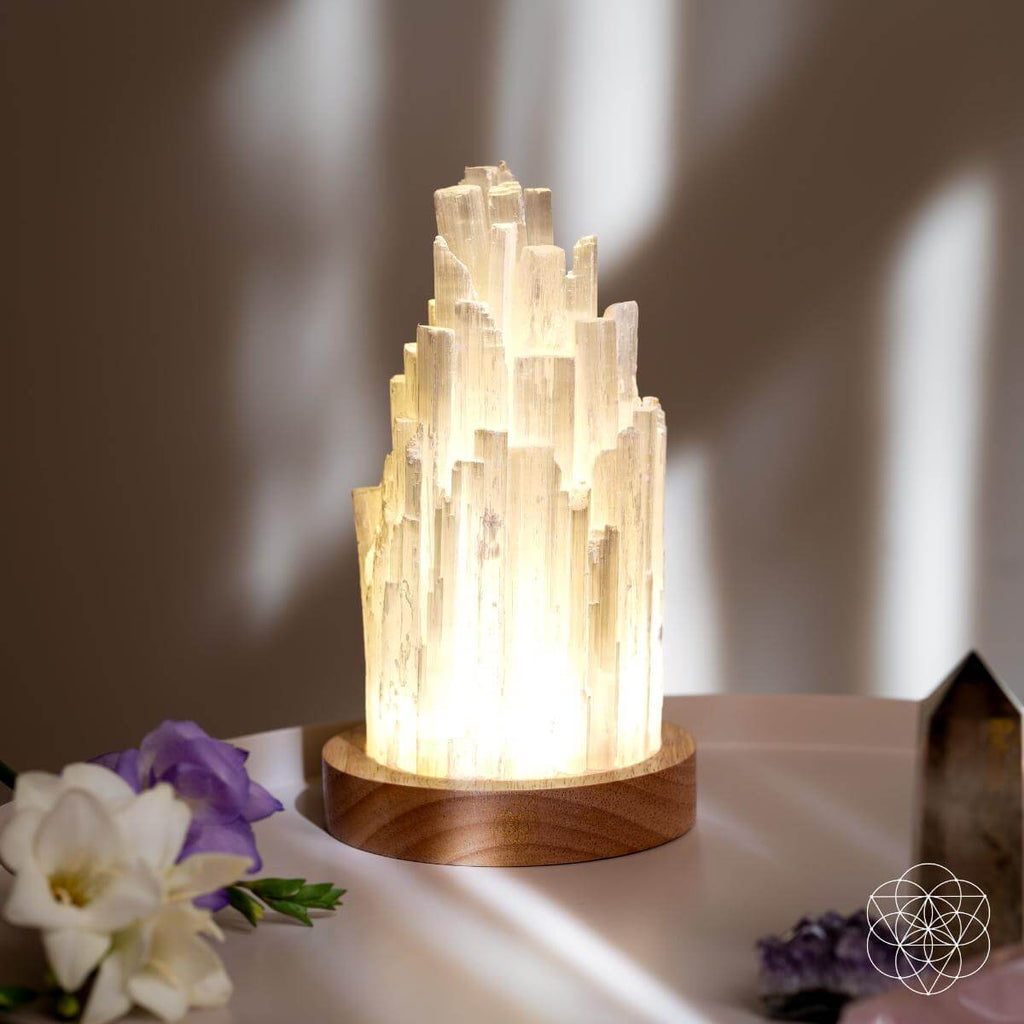 Selenite lamp glowing white crystal tower on round wooden base