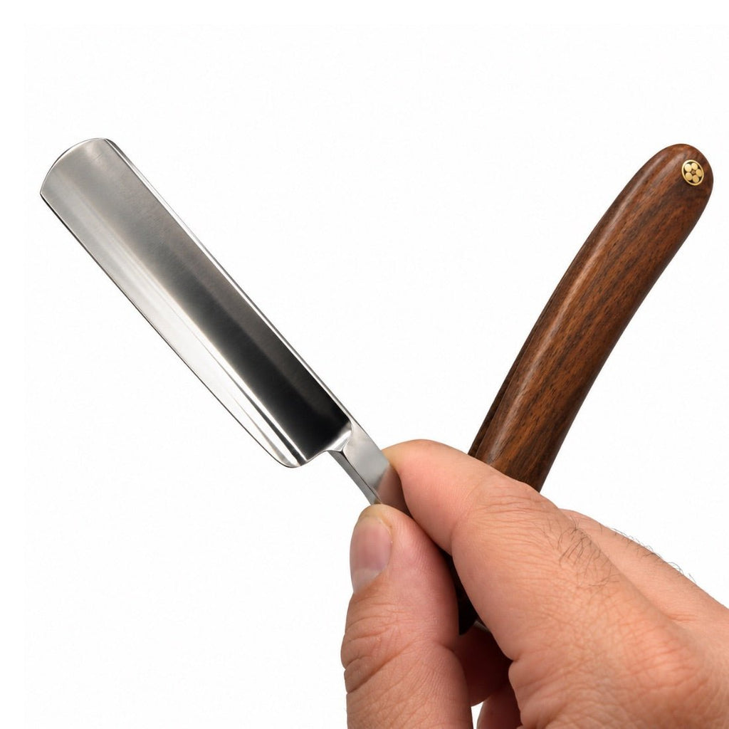 Close-up of straight razor with wood handle and shiny metal blade tip
