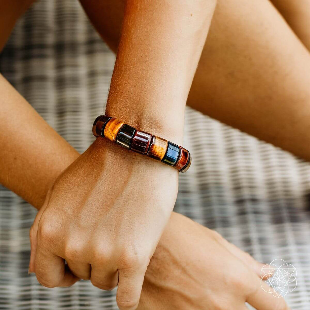 Multicolor beaded bracelet on wrist with blue, red, gold, and black beads