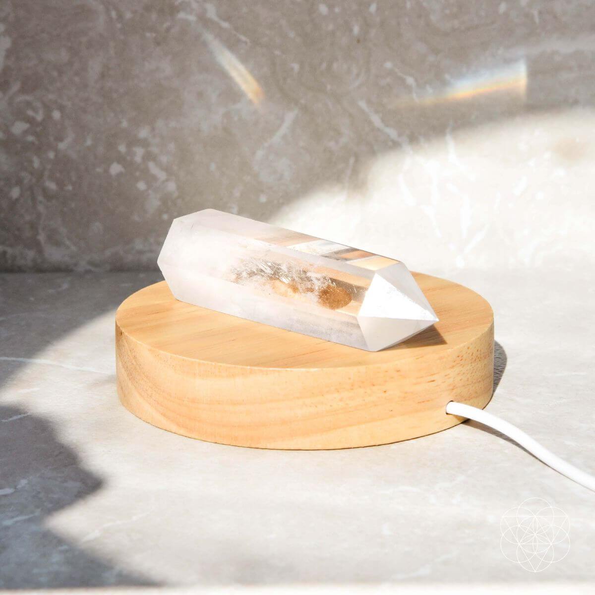 Healing lamp crystal point on round wooden base, unlit with cord extended
