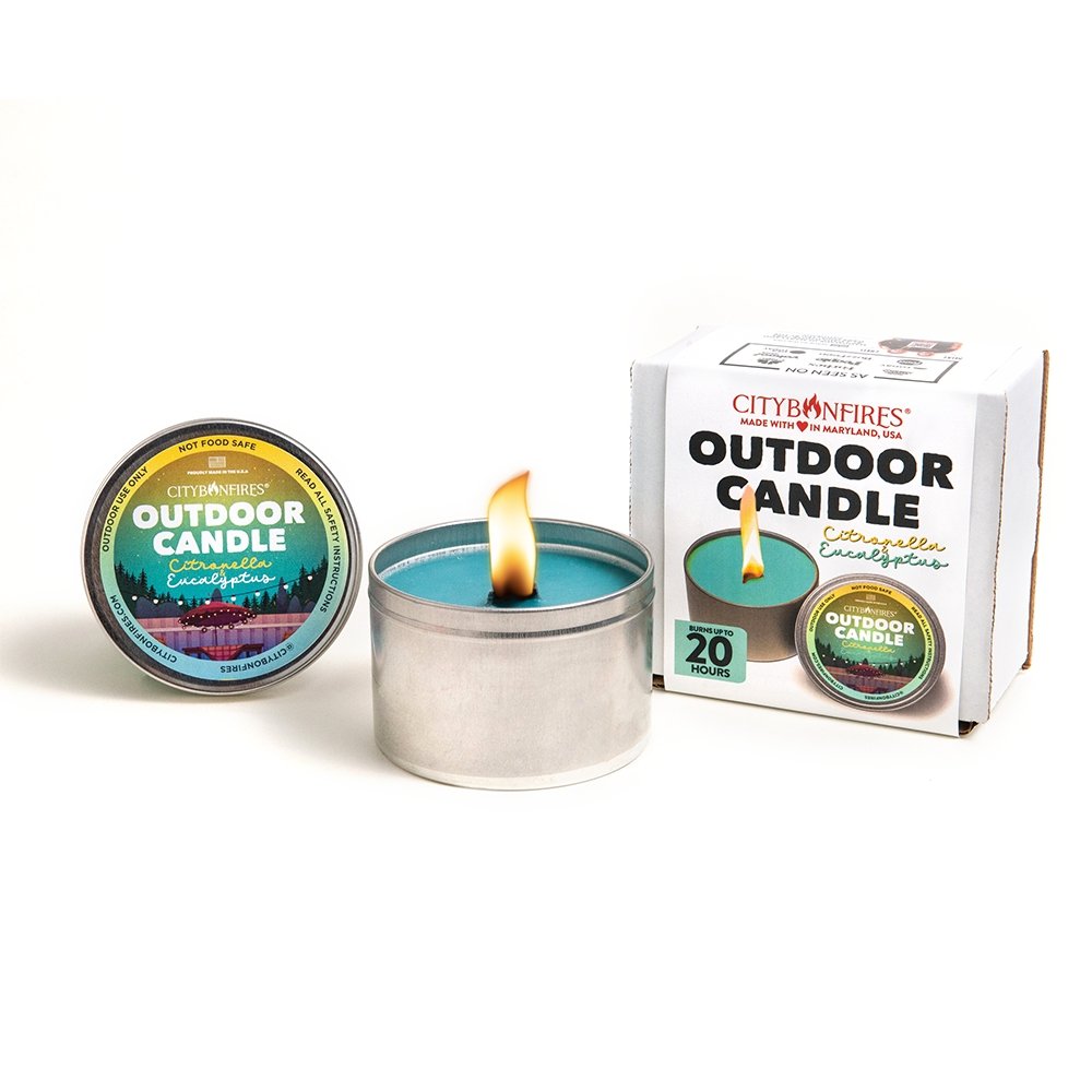 Outdoor candle in silver tin with lit flame and green wax
