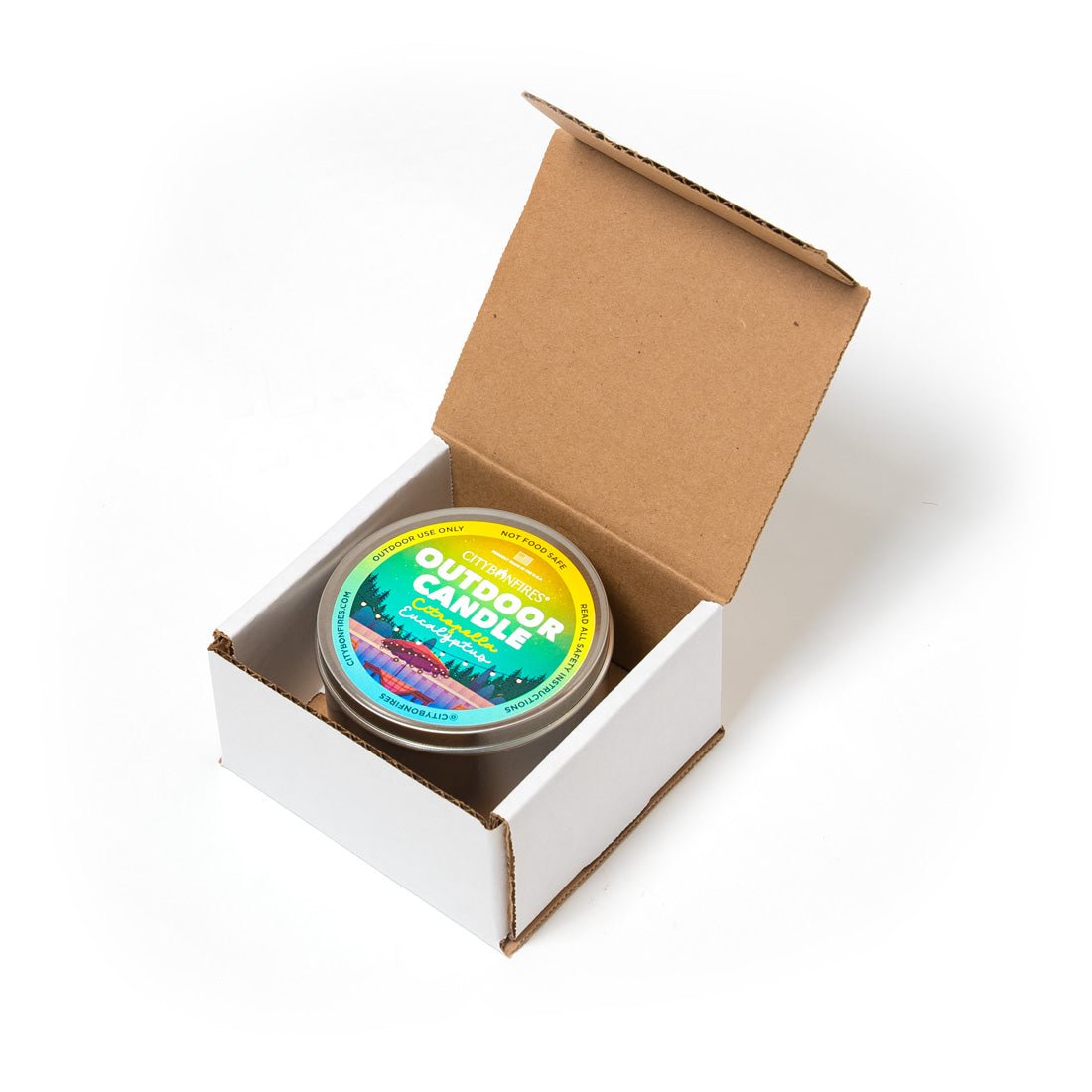 Outdoor candle tin in open box with round lid and green label