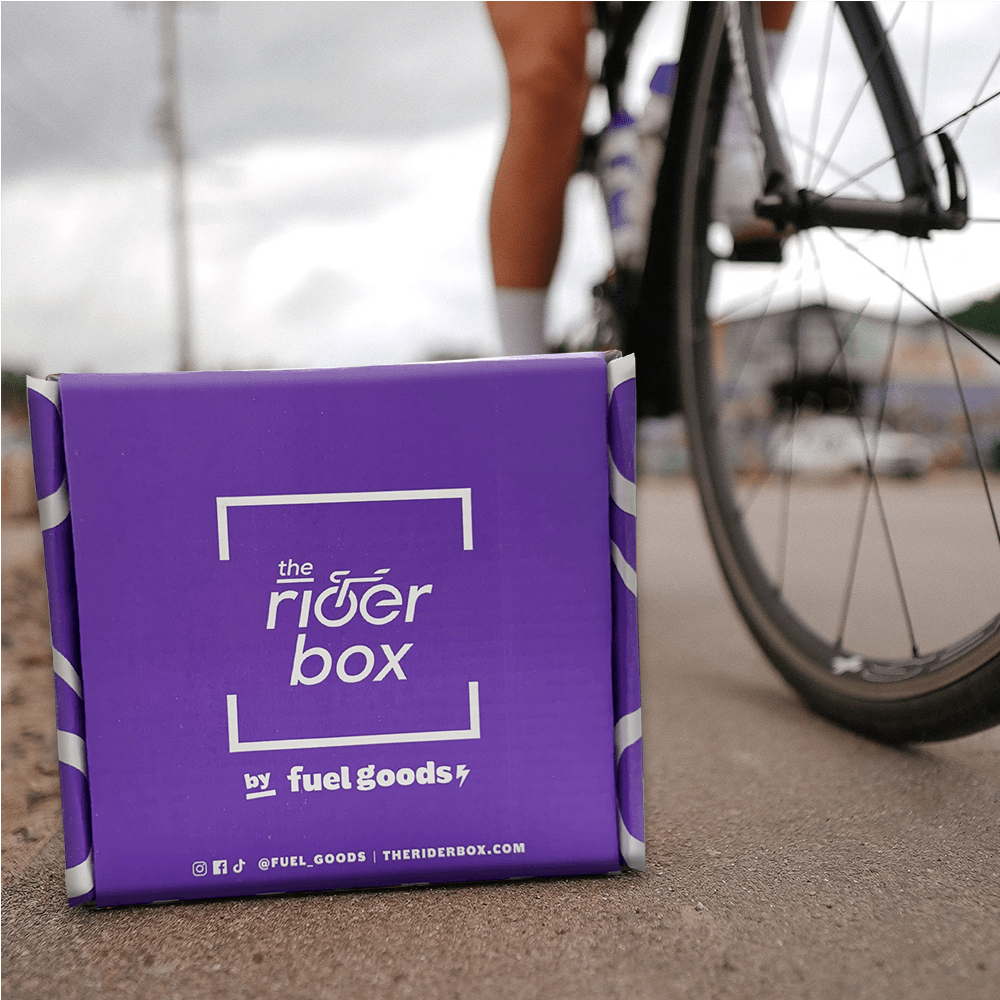 Purple delivery box on a road beside a bicycle wheel