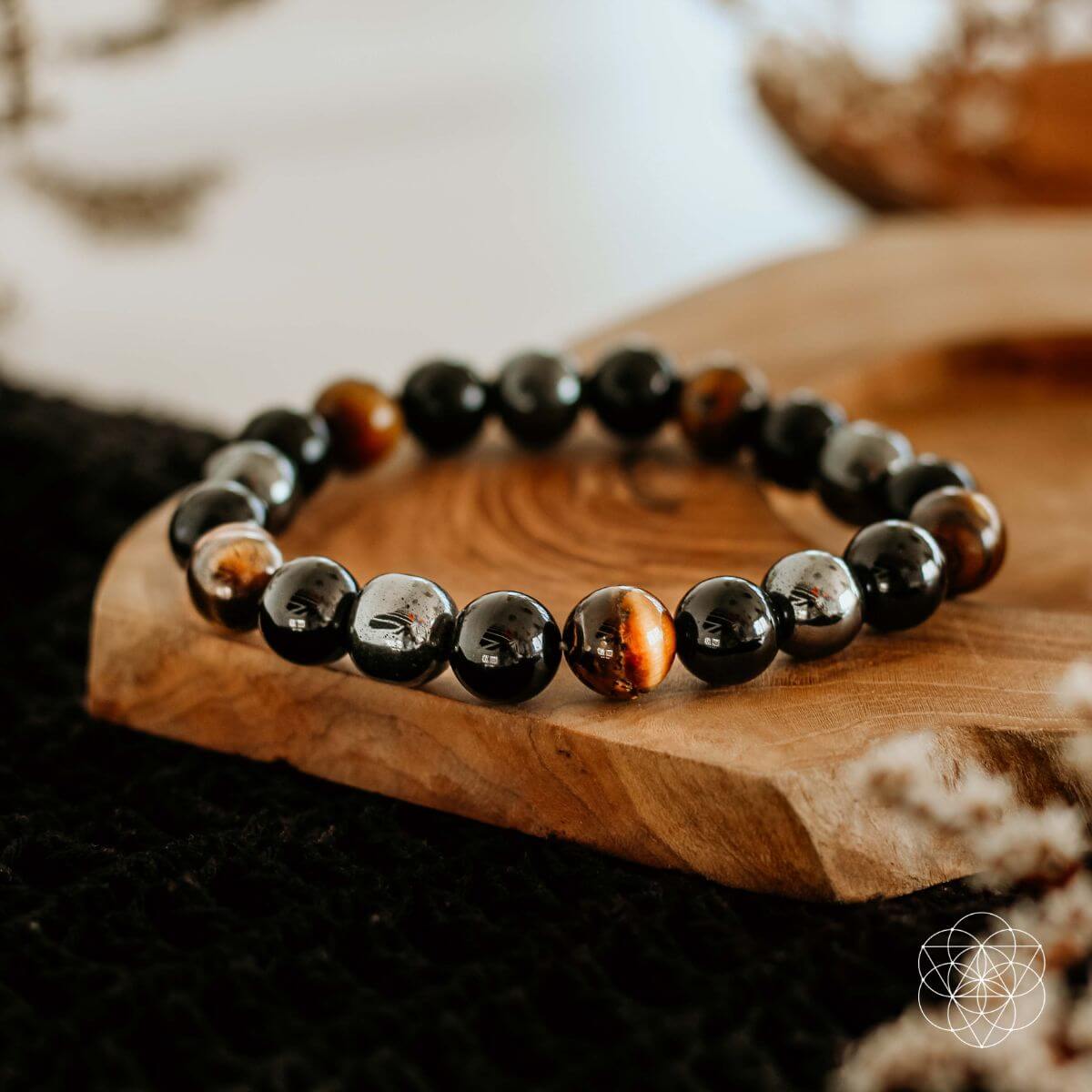 Beaded stretch bracelet with glossy black stones, tiger-eye accents, and silver hematite beads.