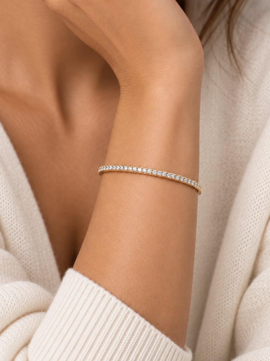 Gold-tone pave cuff bracelet on wrist with rows of small round sparkling stones