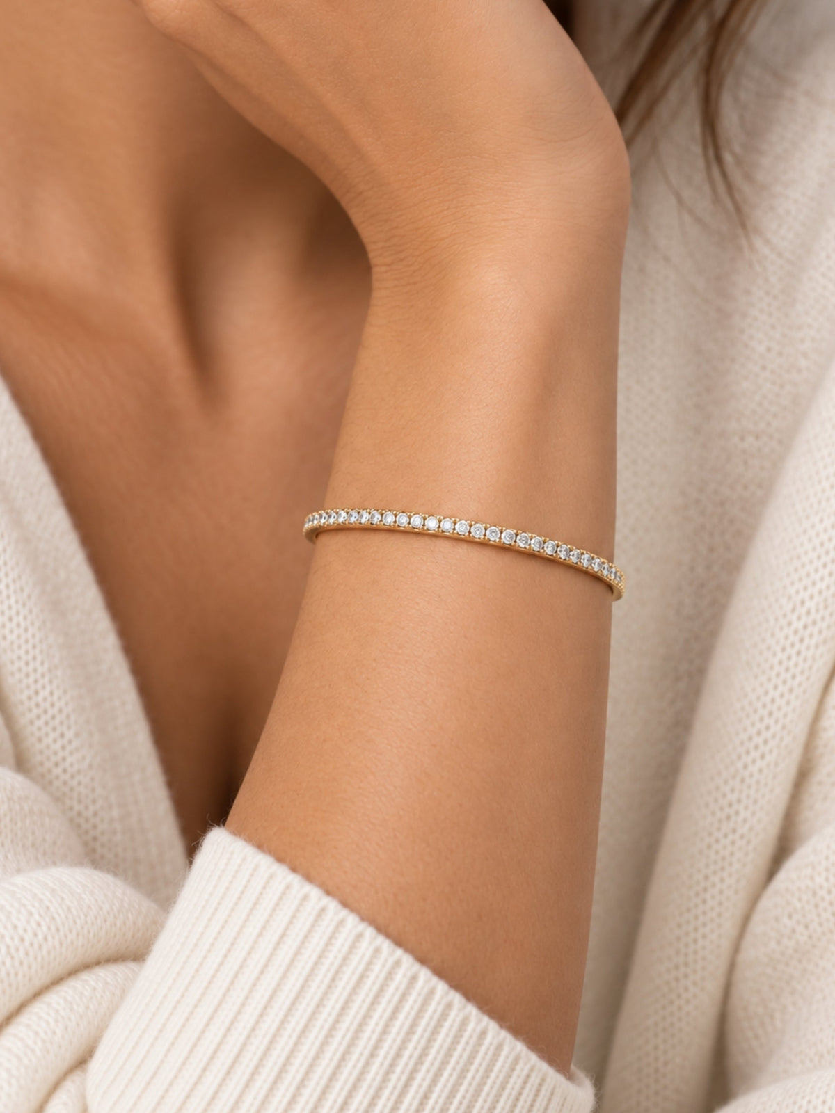 Gold-tone pave cuff bracelet on wrist with rows of small round sparkling stones