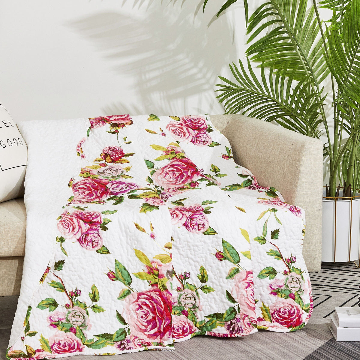 Floral quilted throw blanket draped over beige sofa