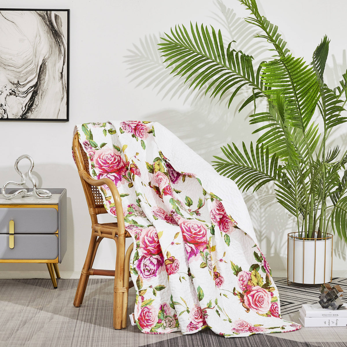 Quilted floral blanket with white base and bright pink rose blooms, soft lightweight feel