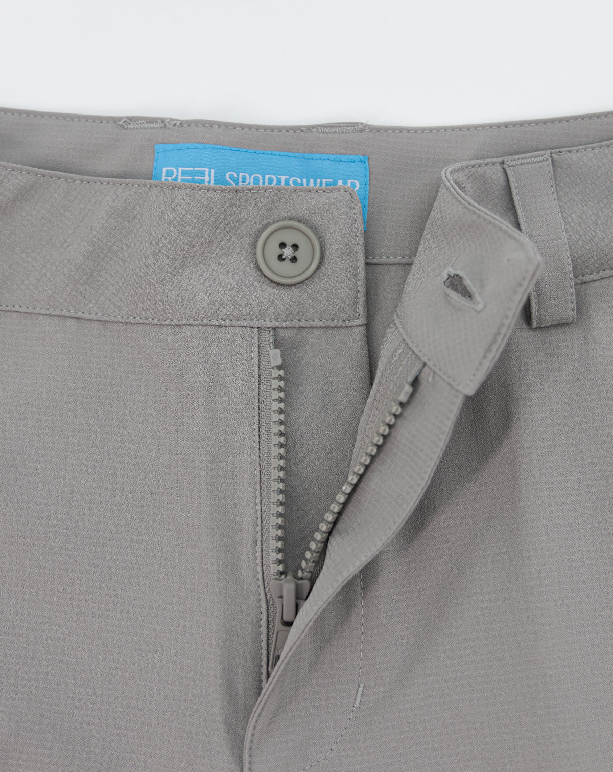 Light gray shorts close-up of waistband button and zipper fly