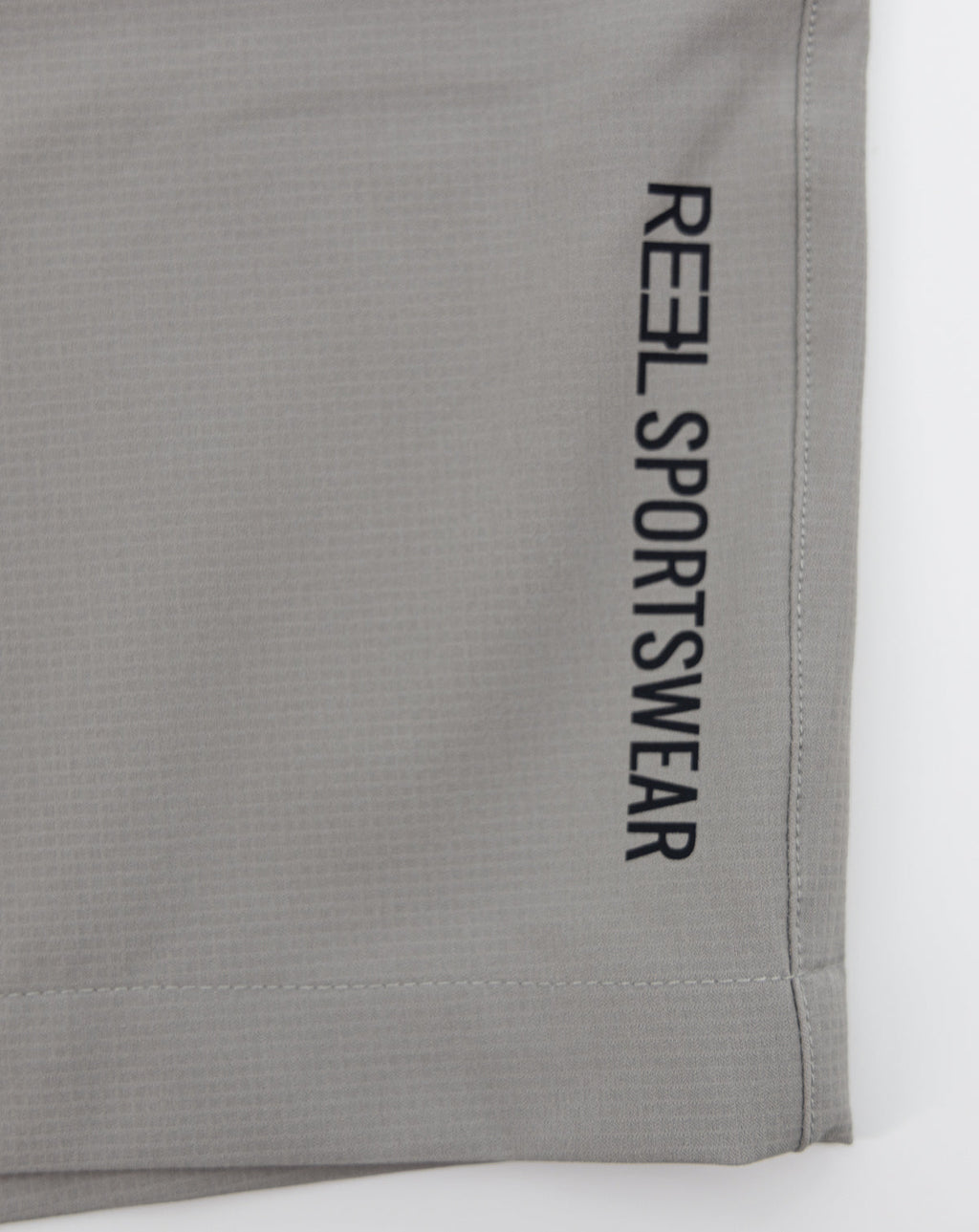 Light gray REEL sportswear shorts with vertical side text