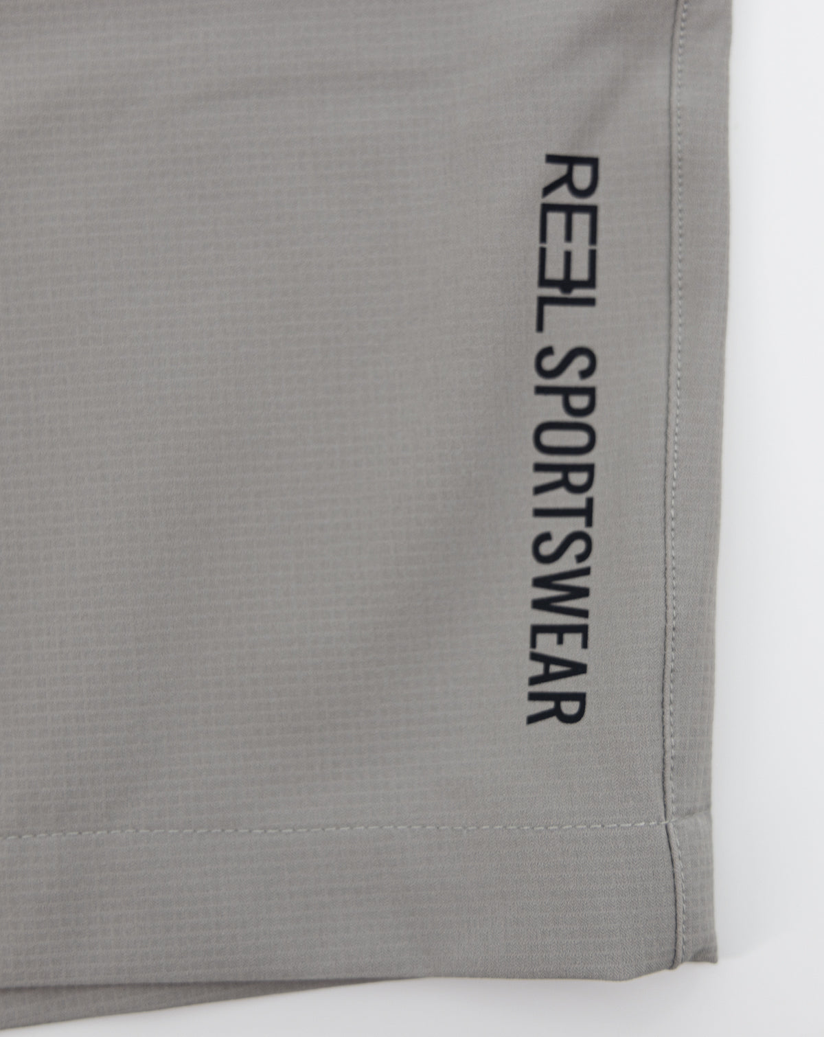 Light gray REEL sportswear shorts with vertical side text