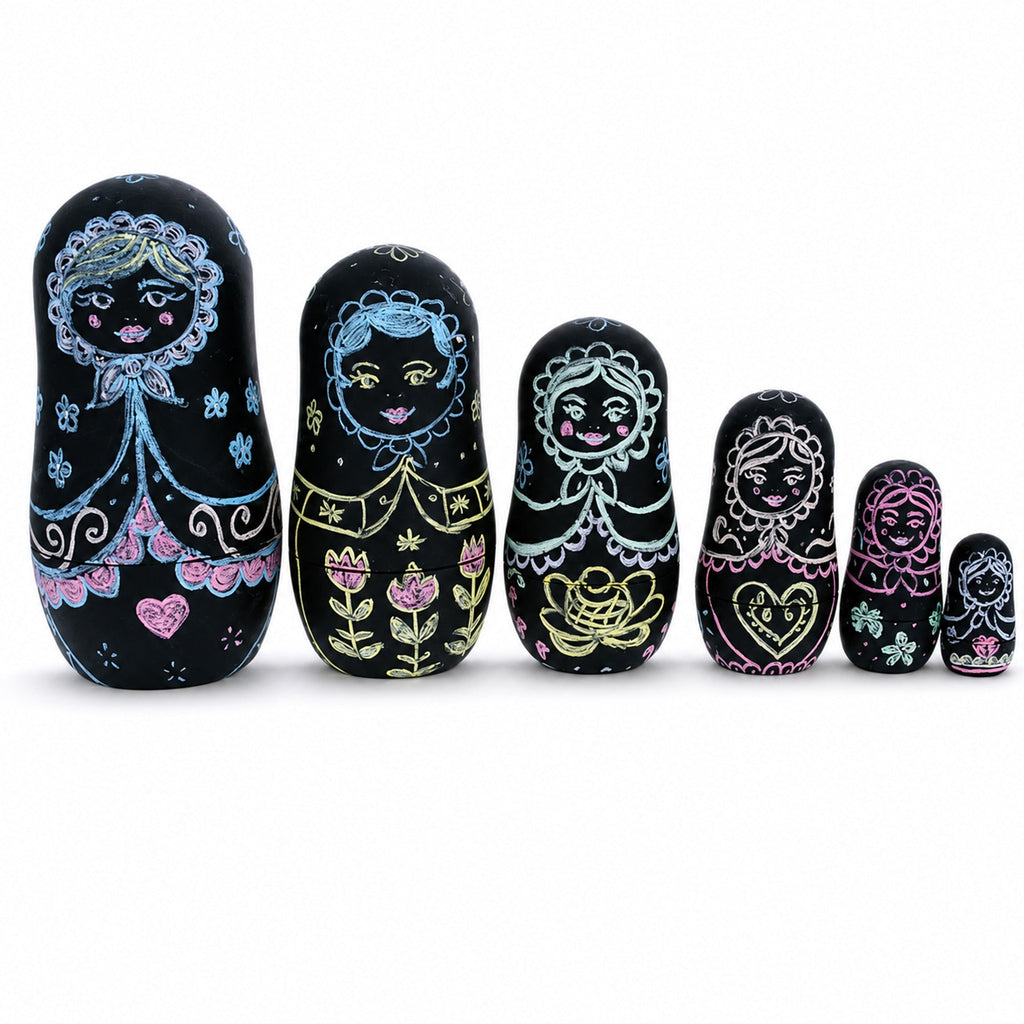 Six black chalkboard nesting dolls decorated with colorful chalk designs