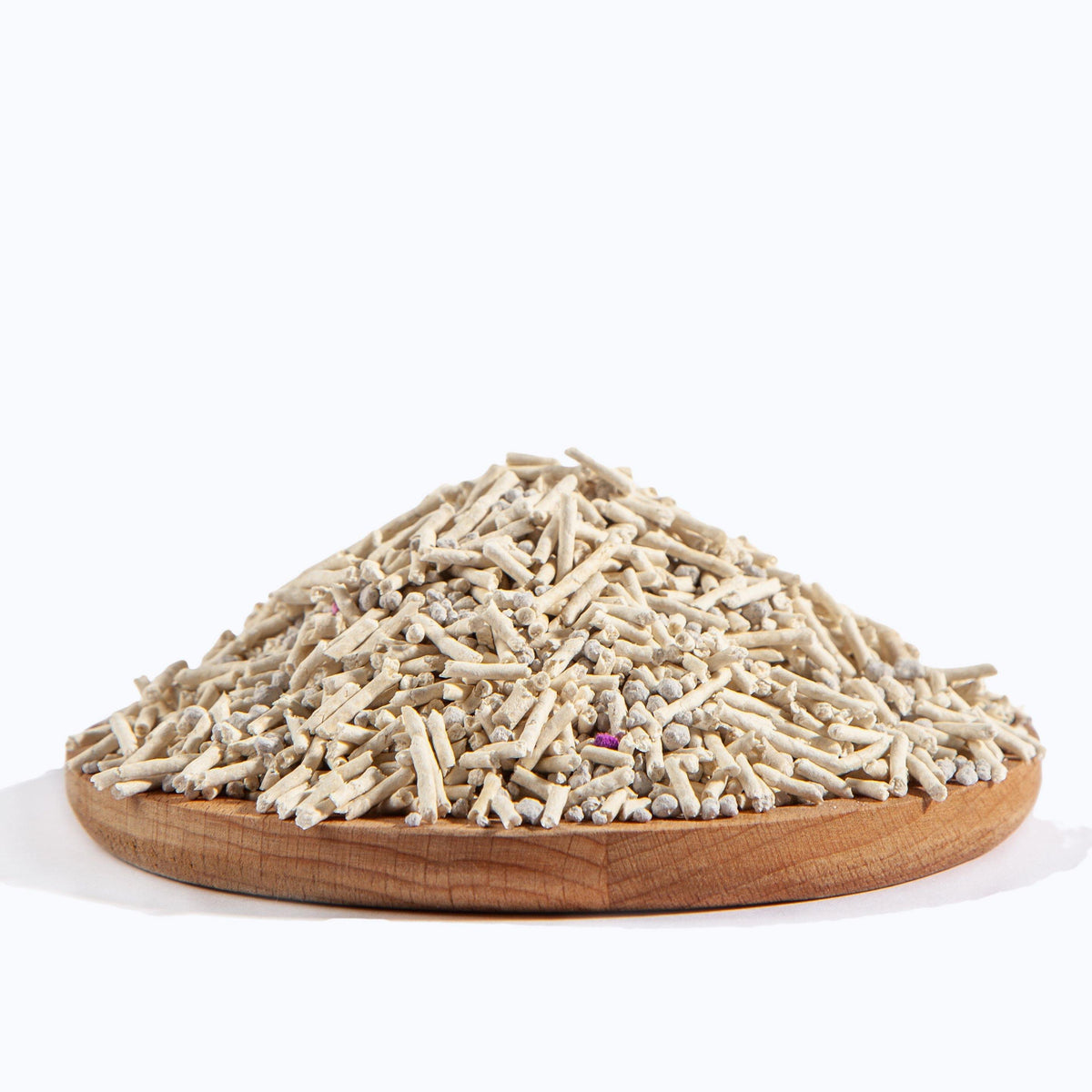 Pile of pale pellet cat litter on a round wooden dish