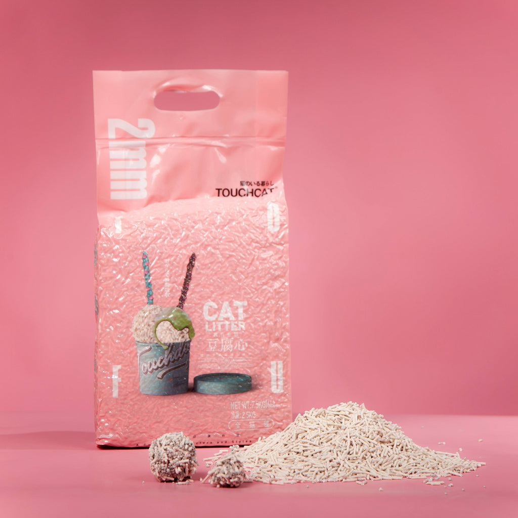 Touchcat cat litter bag beside loose pellets and two compact litter clumps