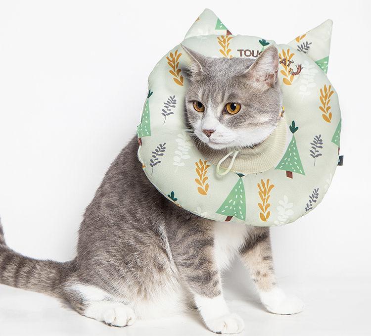 Touchcat Ringlet cat neck protector pillow in a pale green tree print, shown worn by a cat