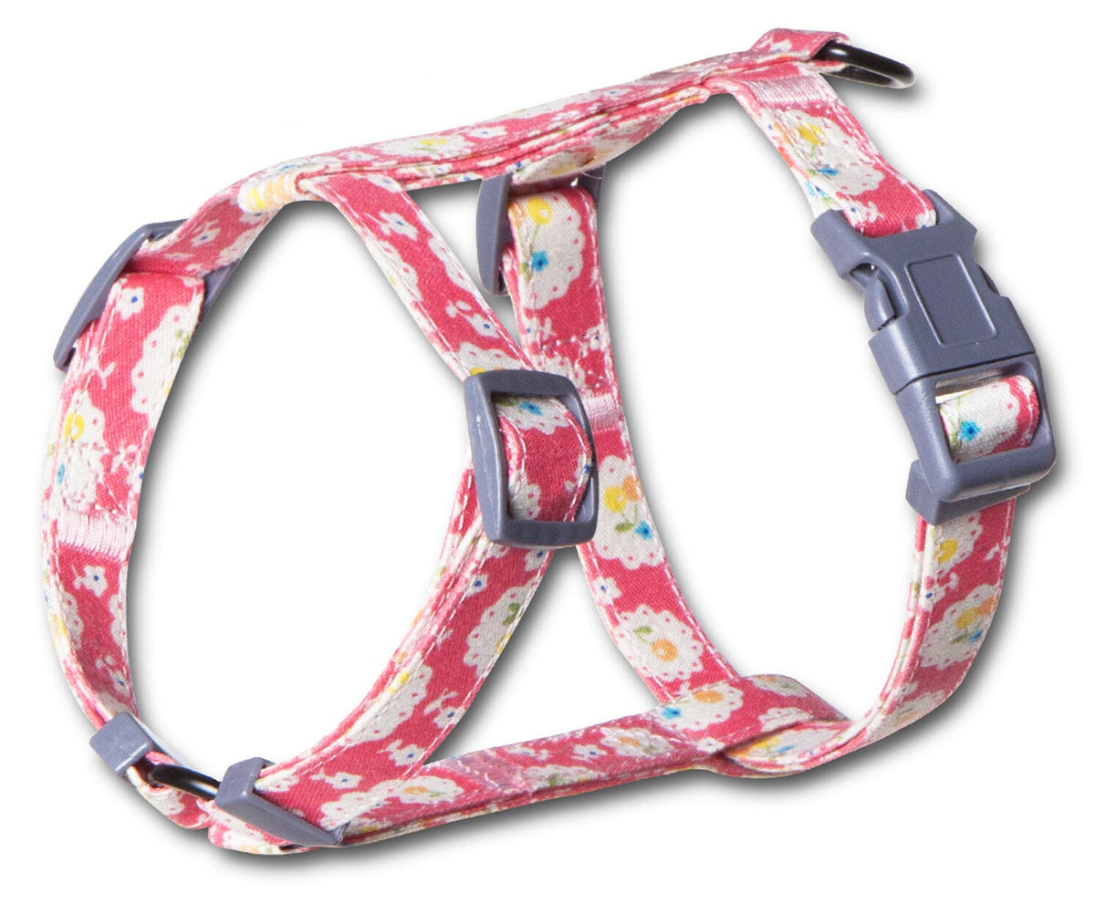 Close-up of pink floral cat harness with adjustable straps and gray buckle.