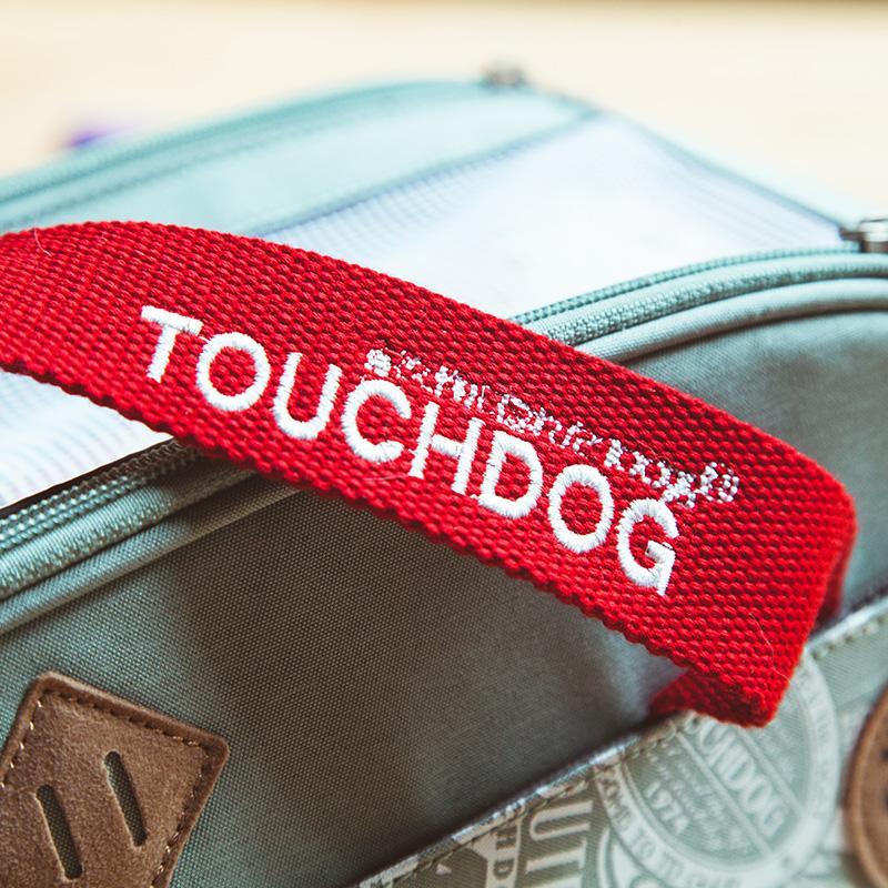 Touchdog carrier detail with red branded handle over teal printed fabric