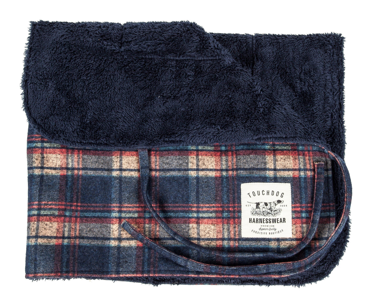 Navy plaid reversible dog mat folded to show its dark plush lining.