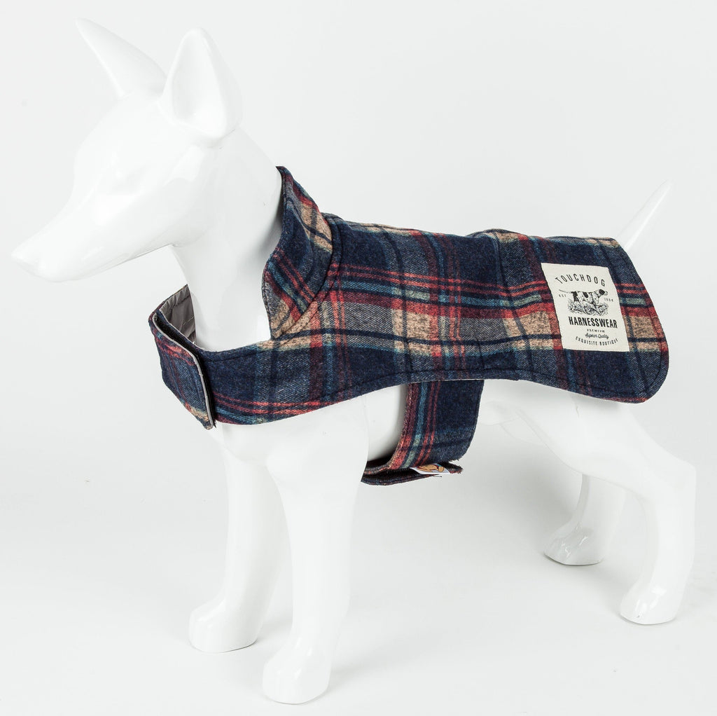 Navy plaid dog jacket shown side-on, with a collar, belly strap, and branded patch.
