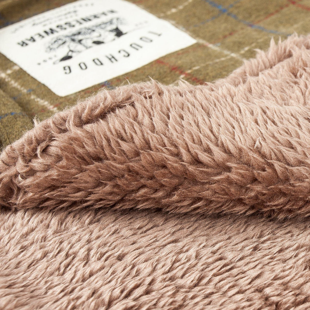 Reversible dog mat with a soft light brown shaggy pile and raised folded edge