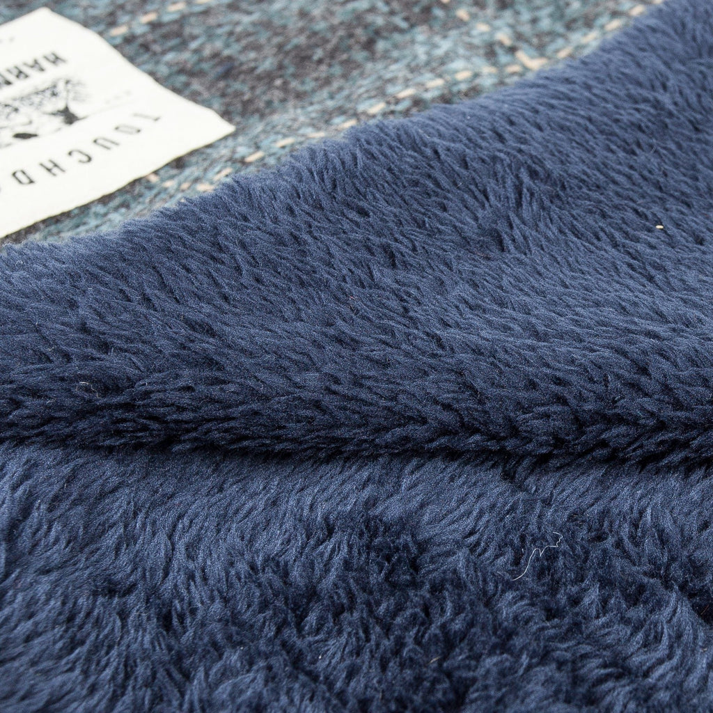 Touchdog mat close-up showing soft navy fleece beside the plaid woven fabric