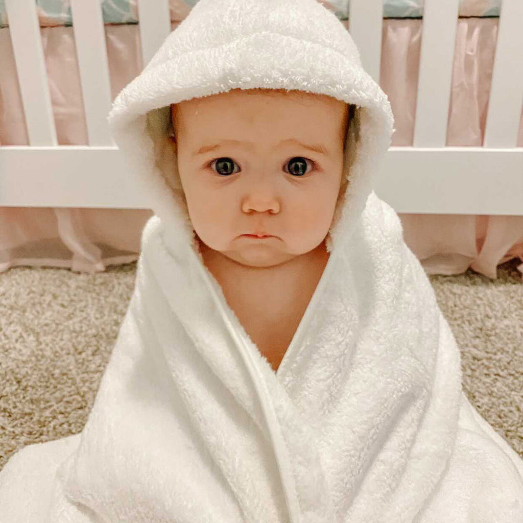 White hooded bath towel with raised hood framing the baby's face
