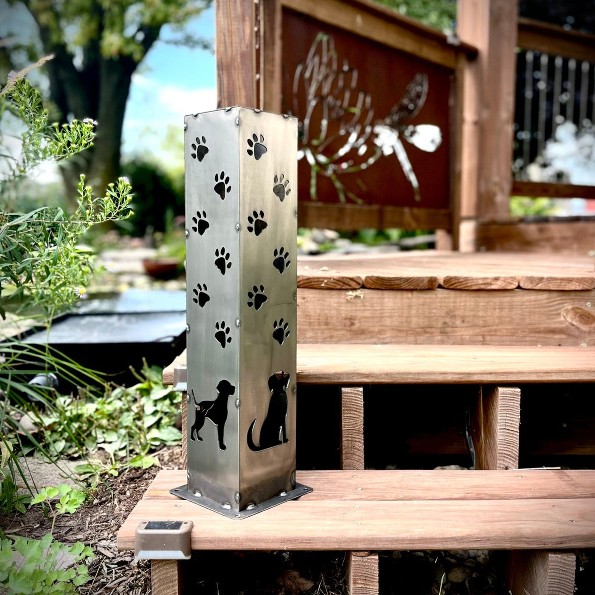 Steel solar pillar with paw prints and dog-and-cat silhouettes, brushed metal finish