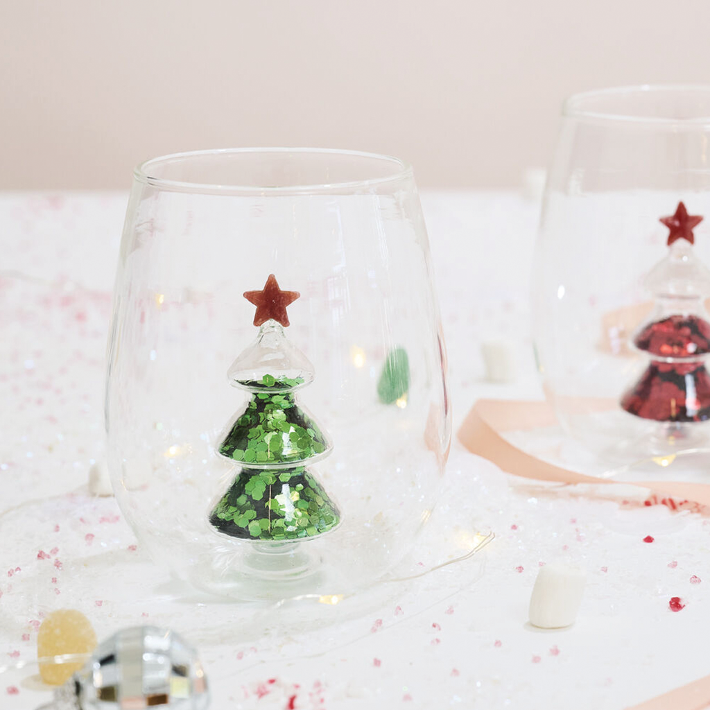 Clear stemless glass with embedded green glitter Christmas tree and red star topper