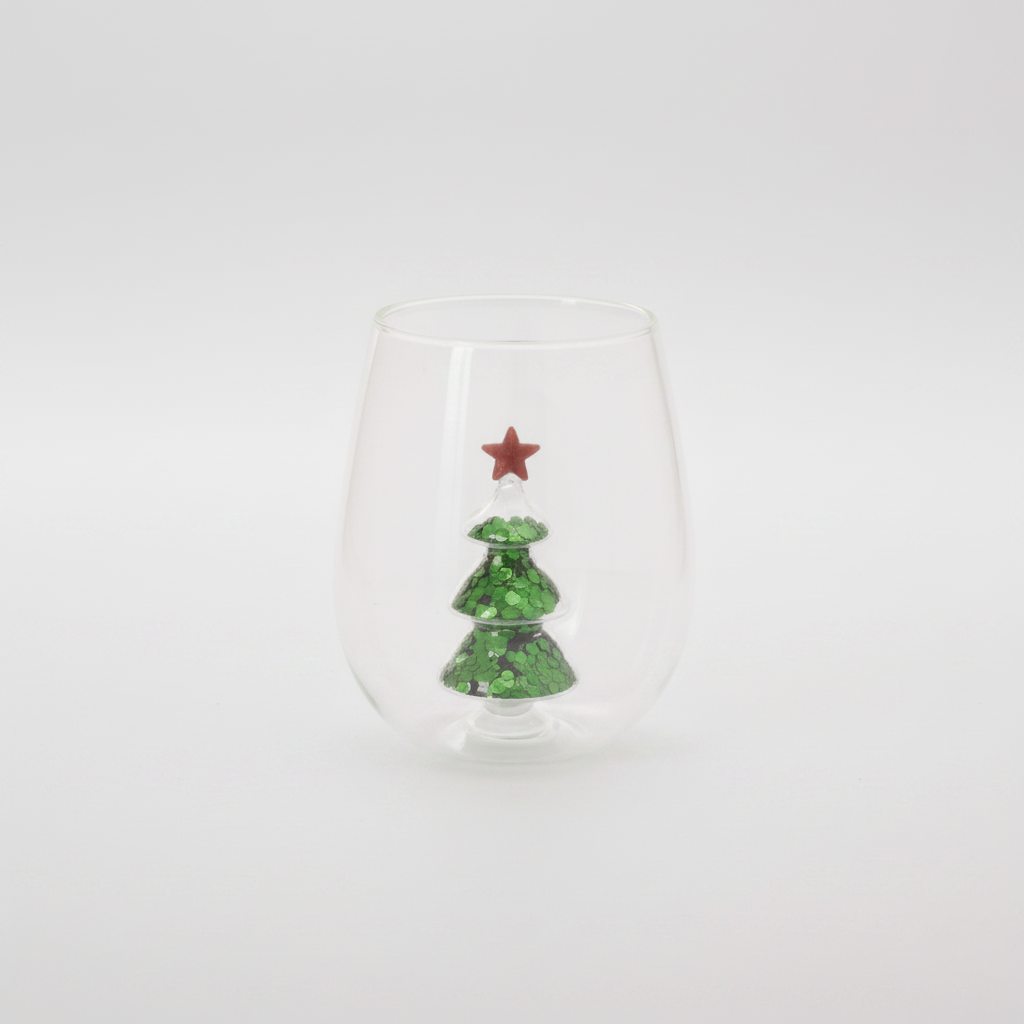 Clear stemless glass with green glitter tree and red star decoration on front