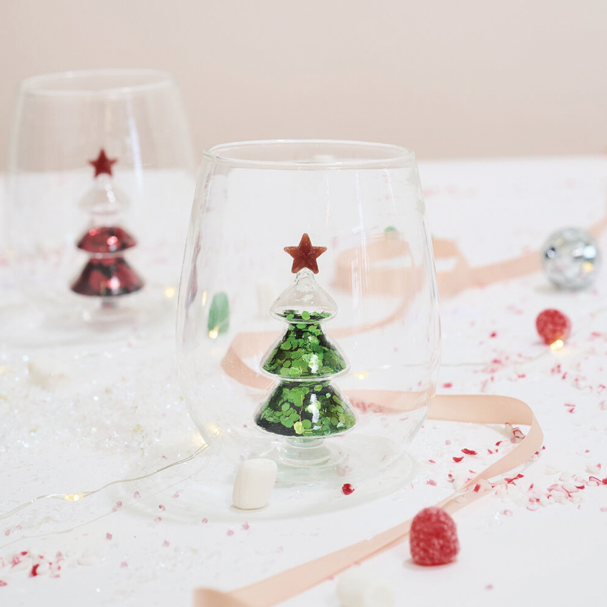 Clear stemless glass with green glitter tree and red star cutout inside