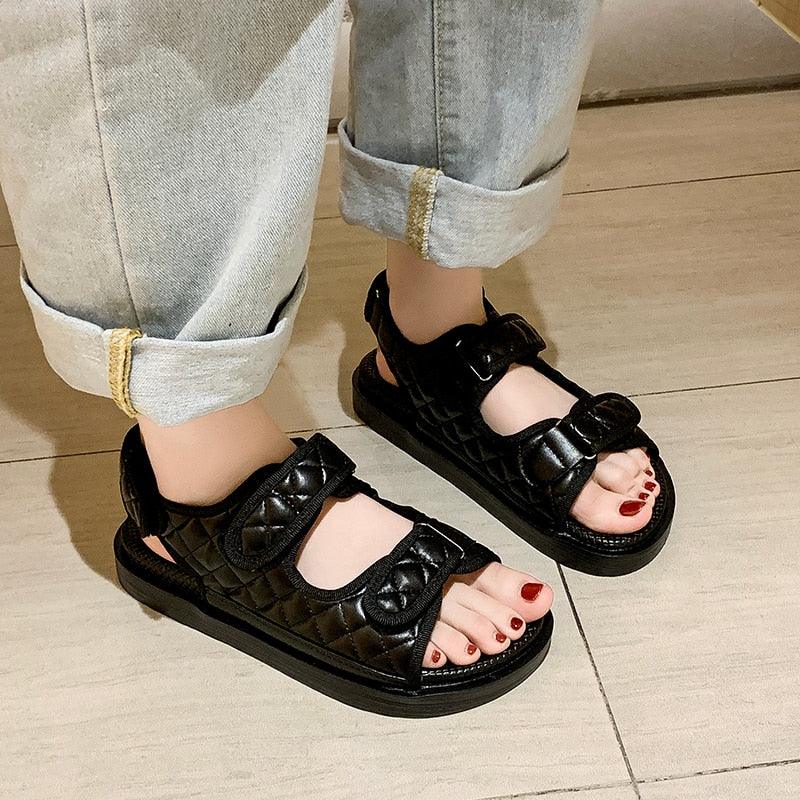 Black flat platform sandals with thick sole and two hook-and-loop straps, open toe