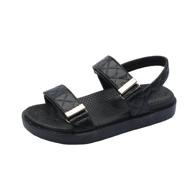 Black flat slide sandals with two quilted straps and gold-tone buckle
