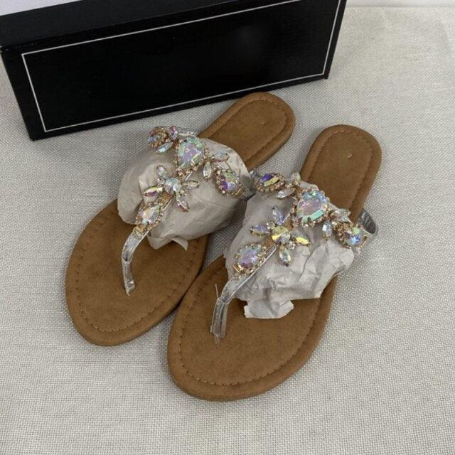 Tan flat open-toe sandals with iridescent crystal flowers and sheer tulle bow straps