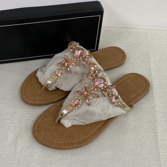 Tan flat open-toe sandals with pink and multicolor rhinestone flower straps