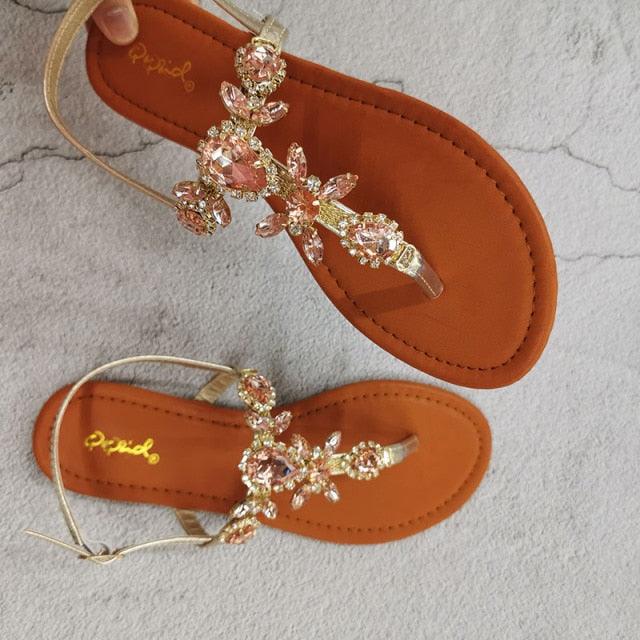 Orange flat open-toe sandals with crystal flower straps and thin ankle pull strap