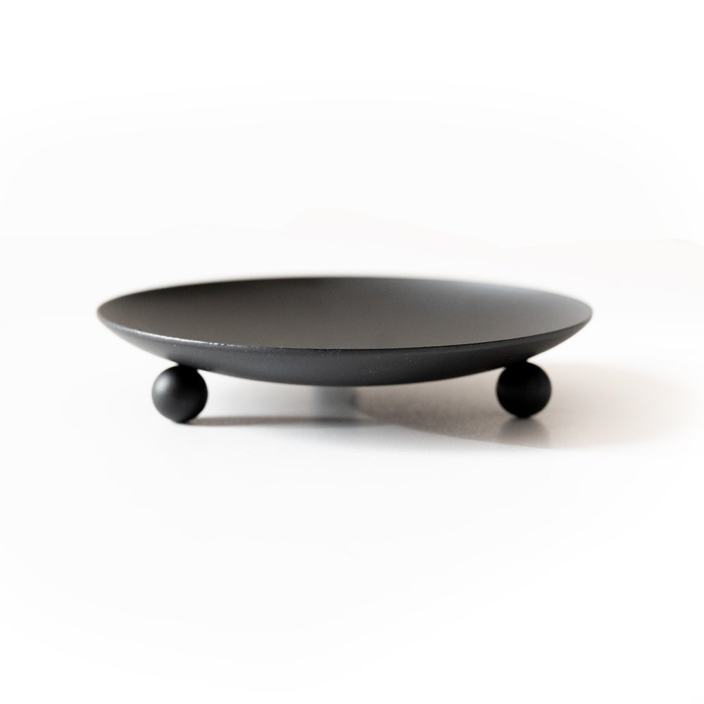 Round black candle trivet base with ball feet, minimalist tabletop design