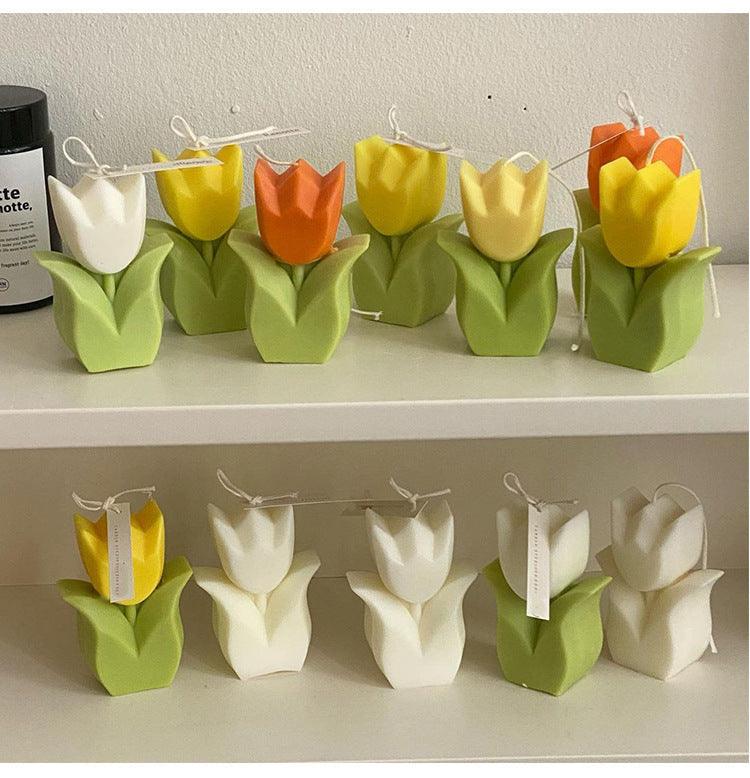 Row of tulip-shaped flower candles with green bases and colorful tulip tops.
