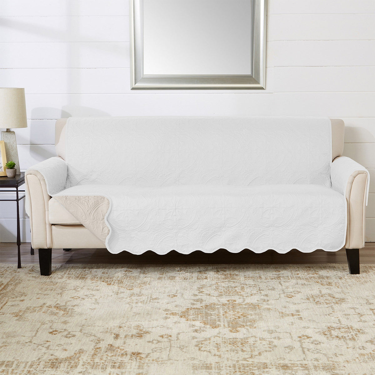 White loveseat protector with scalloped front edge over sofa