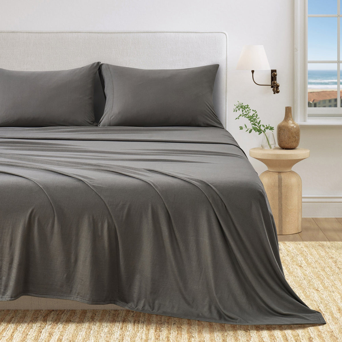 Dark grey jersey knit sheet set with two pillowcases and smooth sheet folds