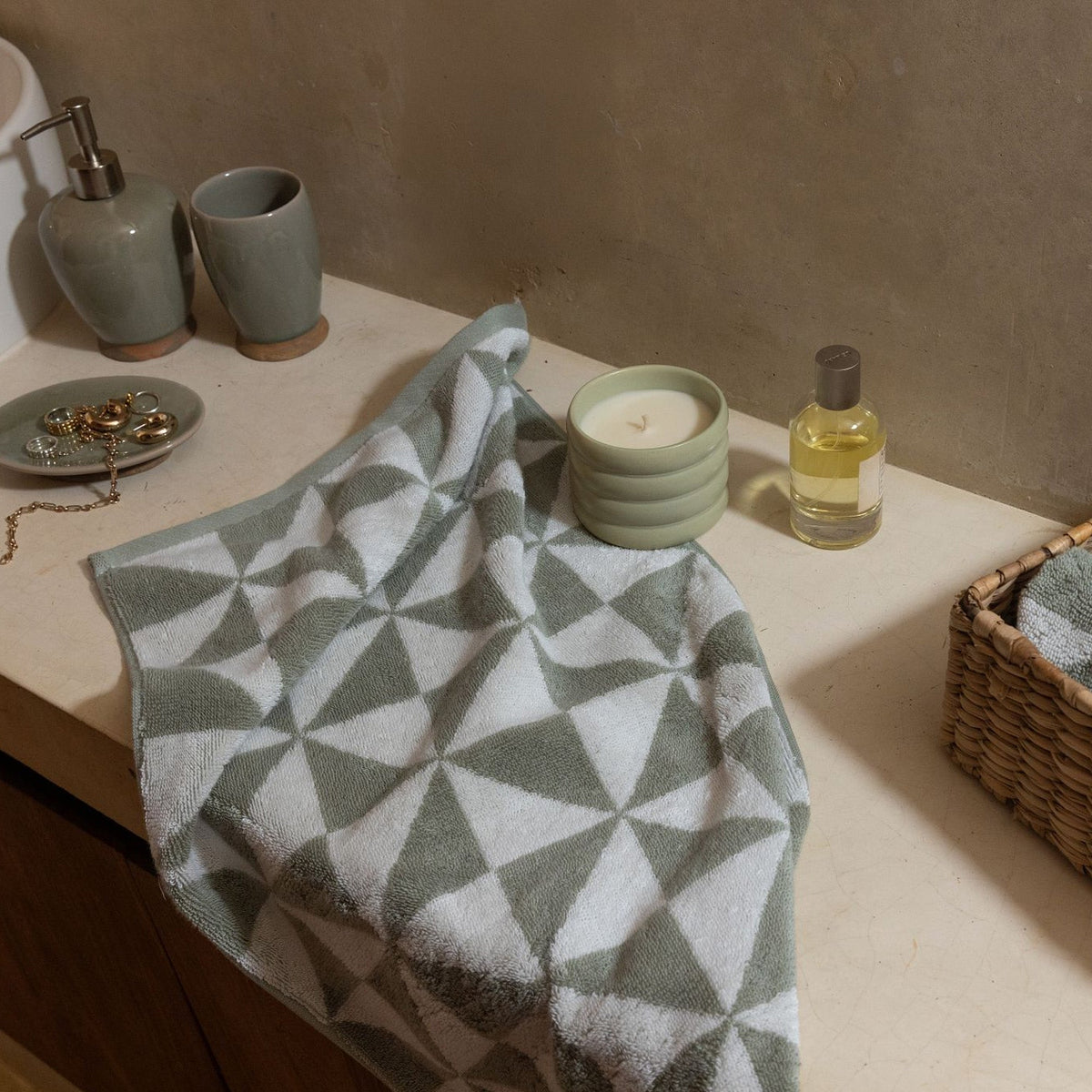 Cotton bath towel with geometric triangles, sage green and ecru, folded