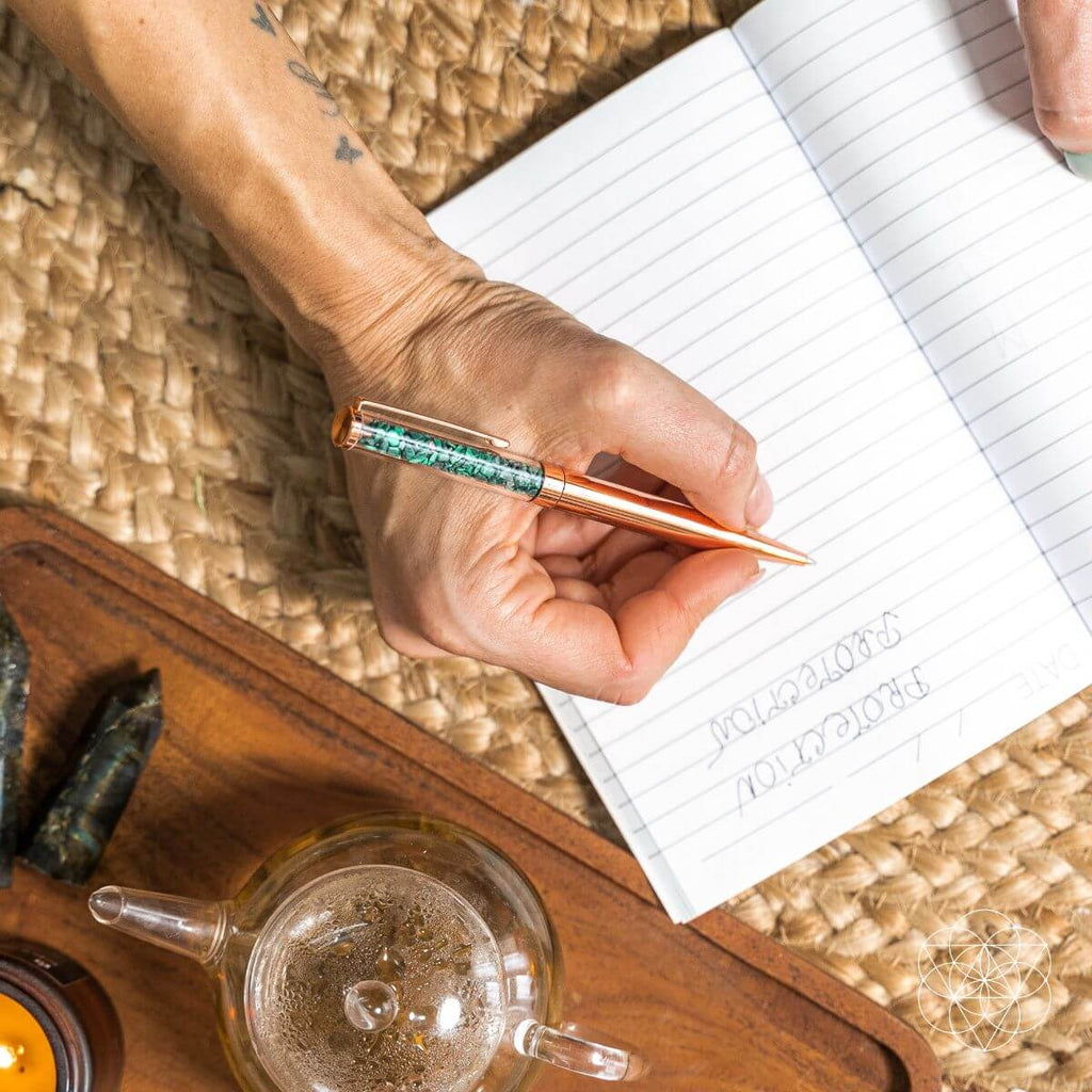 Copper manifestation pen in hand writing in a lined notebook