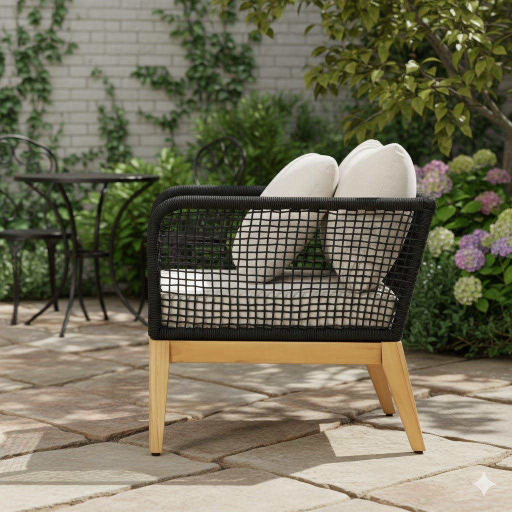 Outdoor arm chair with black woven rope back, white cushions, and teak wood base